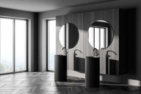 Comfortable two sinks with round mirrors standing on concrete floor in modern bathroom with wooden wall and panoramic windows. 3d renderingの写真素材