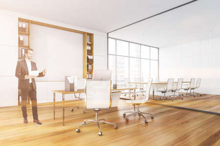 Businessman is researching documents before meeting, COE and leadership at modern panoramic office at international consulting company. Workplace and boss concept. Meeting room. Lens flareの写真素材