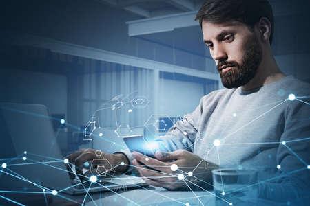 Double exposure of handsome businessman working with laptop and smart phone at office space, social...