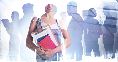 Young smiling office woman with clipboard and documents, double exposure of silhouettes of business people and skyscrapers. Concept of office corporate workの写真素材