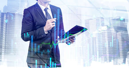 A financial analyst is making notes and trying to settle a new approach to deal with clients needs to boost the business and achieve exceptional financial results. Double exposure. New York cityscapeの写真素材