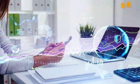 Digital graph rising and falling, office manager with phone in hands, laptop in office interior....