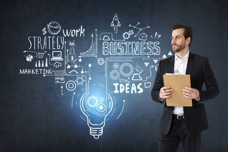 Man manager with clipboard and papers, business strategy plan on dark wall, doodle sketch set. Business finance chart graph, concept of ideaの写真素材