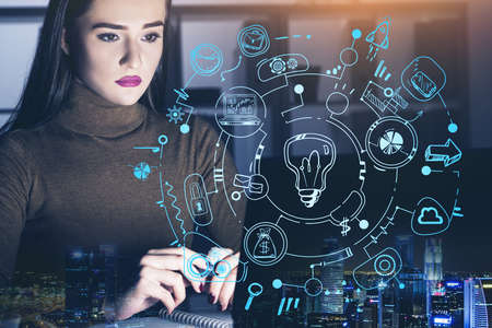 Office manager with laptop, double exposure of night skyscrapers lights and lightbulb drawing with circuit of network connection, icons of communication. Concept of late work and brainstormの写真素材