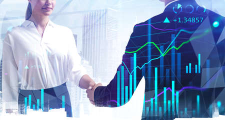 Double exposure of businessman and businesswoman handshake on stock market graph background and New...