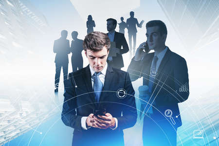 Silhouettes of diverse business people, double exposure of network hud, hologram. Concept of internet connection and teamwork. Toned image. CEO on foreground browsing internet in smartphoneの写真素材