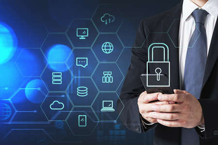 Businessman with smartphone, blue hologram glowing information security icons. Concept of cyber...