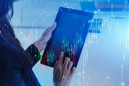 Businesswoman using tablet with business report hologram. Business and financial success concept....