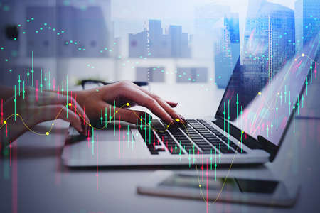 Digital graph rising and falling, woman hands with digital device. Business office interior with...