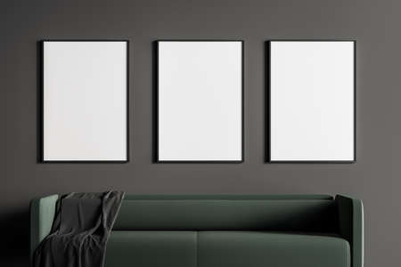 Close up modern living or waiting room interior with furnished by green sofa and three white empty posters on black wall. Minimalist design concept. 3D renderingの写真素材