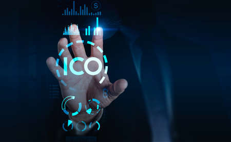 Businessman finger pointing at initial coin offering, double exposure symbols on a virtual screen...