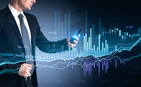 Businessman in suit using phone, stock market changes, business candlesticks graph chart. Double...