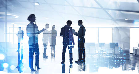 Silhouettes of diverse business people working together, toned image of office interior and skyscrapers. Concept of modern office with managers, partnersの写真素材