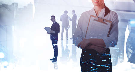 Office woman and man with business papers, background of city buildings blurred. Concept of business partners and network in international companyの写真素材