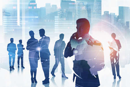 Office man using smartphone, double exposure of office buildings and business people silhouettes. Partners and office workers, worldwide connection. Concept of teamwork and technologyの写真素材