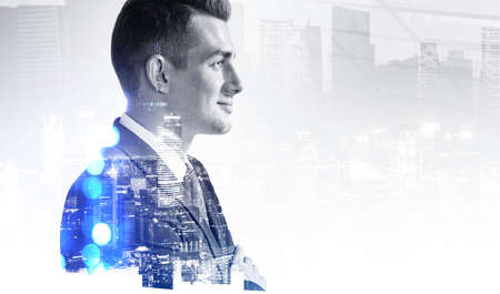 Businessman smiling face, night business buildings, toned image double exposure. Concept of successful manager and business leadershipの写真素材