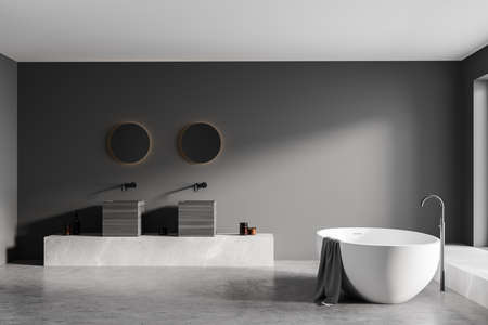 Dark gray bathing room with white bathtub and gray towel, two sinks with mirrors on concrete floor. Luxury minimalist bathroom interior, 3D renderingの写真素材