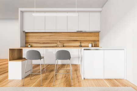 Light kitchen set with wooden table and two gray bar chairs, wooden floor. Kitchen interior with...
