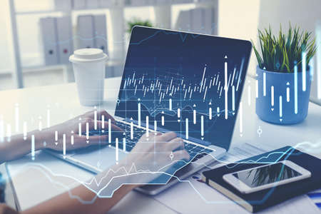 Businesswoman hands typing on keyboard of laptop on the office table, double exposure of stock...
