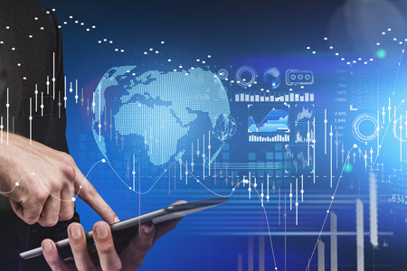 Businessman hands and finger touch tablet display. Stock market changes candlesticks, data...