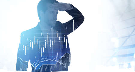 Businessman looking at long distance, in black suit. Skyscrapers and stock market changes with candlesticks, double exposure. Concept of office worker, trader and financial advisorの写真素材