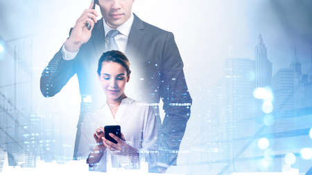 Businessman and businesswoman with smartphones, night business buildings toned double exposure....