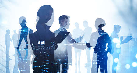 Diverse business people, double exposure of teamwork and skyscrapers at night, evening lights. Concept of working together, international communication and partnersの写真素材