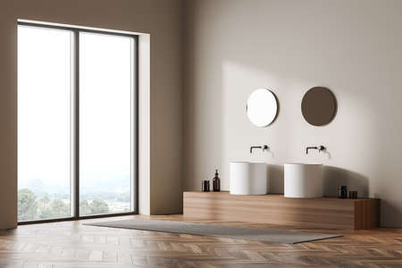 Bright bathroom interior with panoramic window with countryside view, two sinks and mirrors, carpet, oak wooden parquet floor. Concept of cleanliness and tidiness. Minimalist comfortable designの写真素材