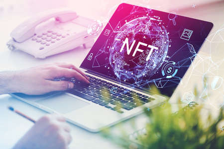 Man hands with laptop on table, non-fungible token hologram on screen, nft with network circuit and globe. Concept of cryptocurrency art and technologyの写真素材