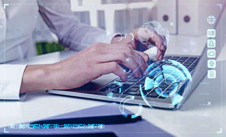 Businessman wearing white shirt is typing message via laptop. Office workplace with desk in the...