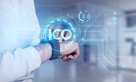 Businesswoman hands using smartwatch checking ICO report and cryptocurrency market behavior based on...