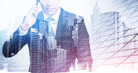 Office man talking on the phone, business buildings double exposure, toned image. Concept of international communication and technology, leadershipの写真素材