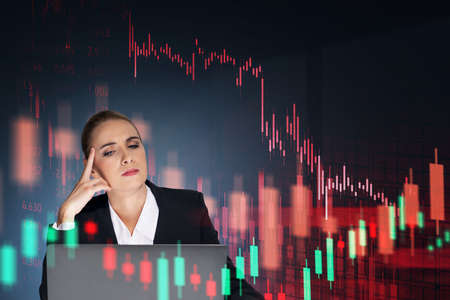Woman in suit sitting and thinking looking at the device screen. Stock market negative statistics,...
