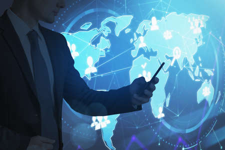 Office man in black suit using phone in hand, double exposure of earth world map and icons of network circuit and communication. Concept of technology and worldwide communicationの写真素材