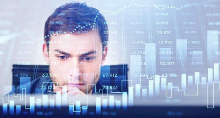 Portrait of trader businessman who is carrying out a research on desktop computer. Forex graph...
