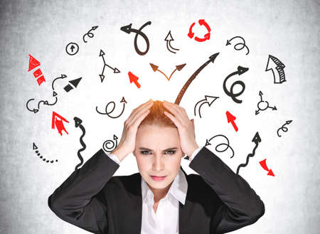 Boss woman with headache, depressed and under pressure. Black and red arrows with multiple direction. Concept of big problem and challengeの写真素材
