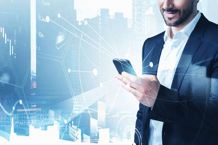 Businessman in formal suit checking stock market rates in smartphone. Hologram charts. Business and...