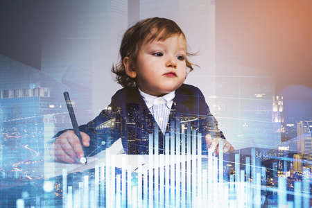 Little child boy with pen, double exposure of financial chart with bar rising, Singapore at night. Office work and stock market changes. Concept of education and business coursesの写真素材