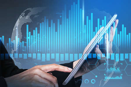 Business woman hand using tablet with stock market report hologram. Business and financial success...
