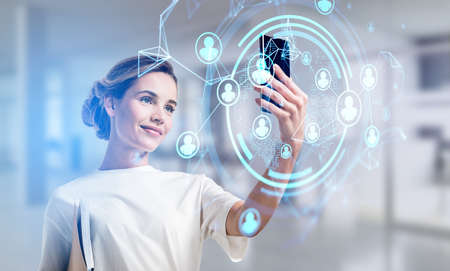 Businesswoman in casual t-shirt using smartphone to communicate with business colleagues on the...