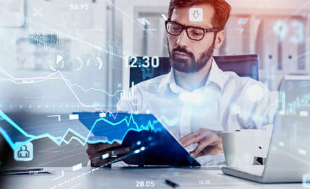 Financial charts showing increase of price in stock market, internet trading concept. Handsome beard...