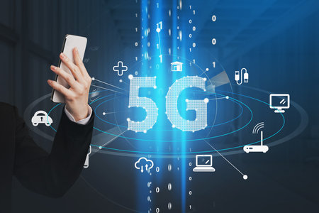 Business Womans hand holds smartphone and browsing the Internet. Blue hologram icons of 5G digital network. Wireless systems and high speed signal.の写真素材