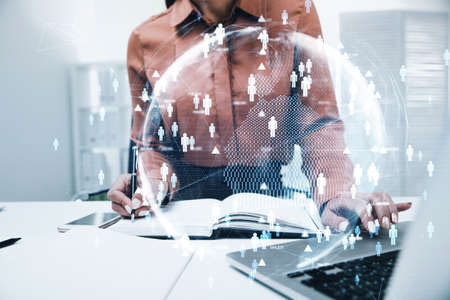 Businesswoman sitting at the table, working on laptop conducting a research to hire high qualified employees for international projects and taking notes. Concept of HR and new candidates.の写真素材
