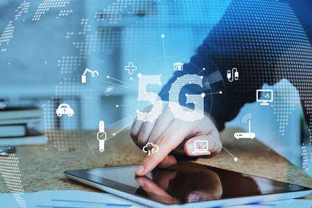 Businessman working with tablet device and browsing the Internet using touch screen. Blue hologram...