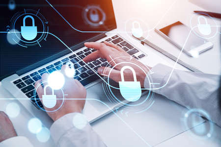Hands are typing on laptop keyboard, blue glowing information protection padlock icons. Concept of...