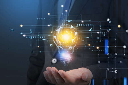 Businessman hand holding digital hologram of colorful light bulb as a concept of new idea for start up. Concept of creativity and brainstorming.の写真素材