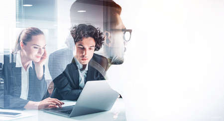 Group of business people in formal suits working together on laptop, pensively looking into a...