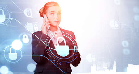 Attractive businesswoman talking smartphone and pondering about data security and information protection. White glowing padlock icons. Concept of cyber securityの写真素材