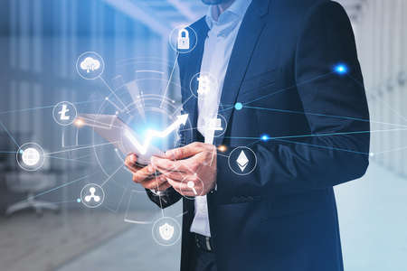 Businessman wearing formal suit is holding tablet device. Concept of analyzing the value of...