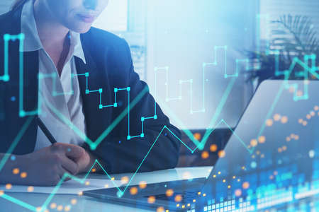 Businesswoman, stock trader analyzing stock data to apply new strategy to beat the market. Using...